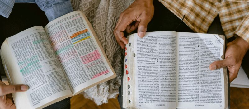 Twee mannen onderzoeken samen de Bijbel_pexels-tima-miroshnichenko